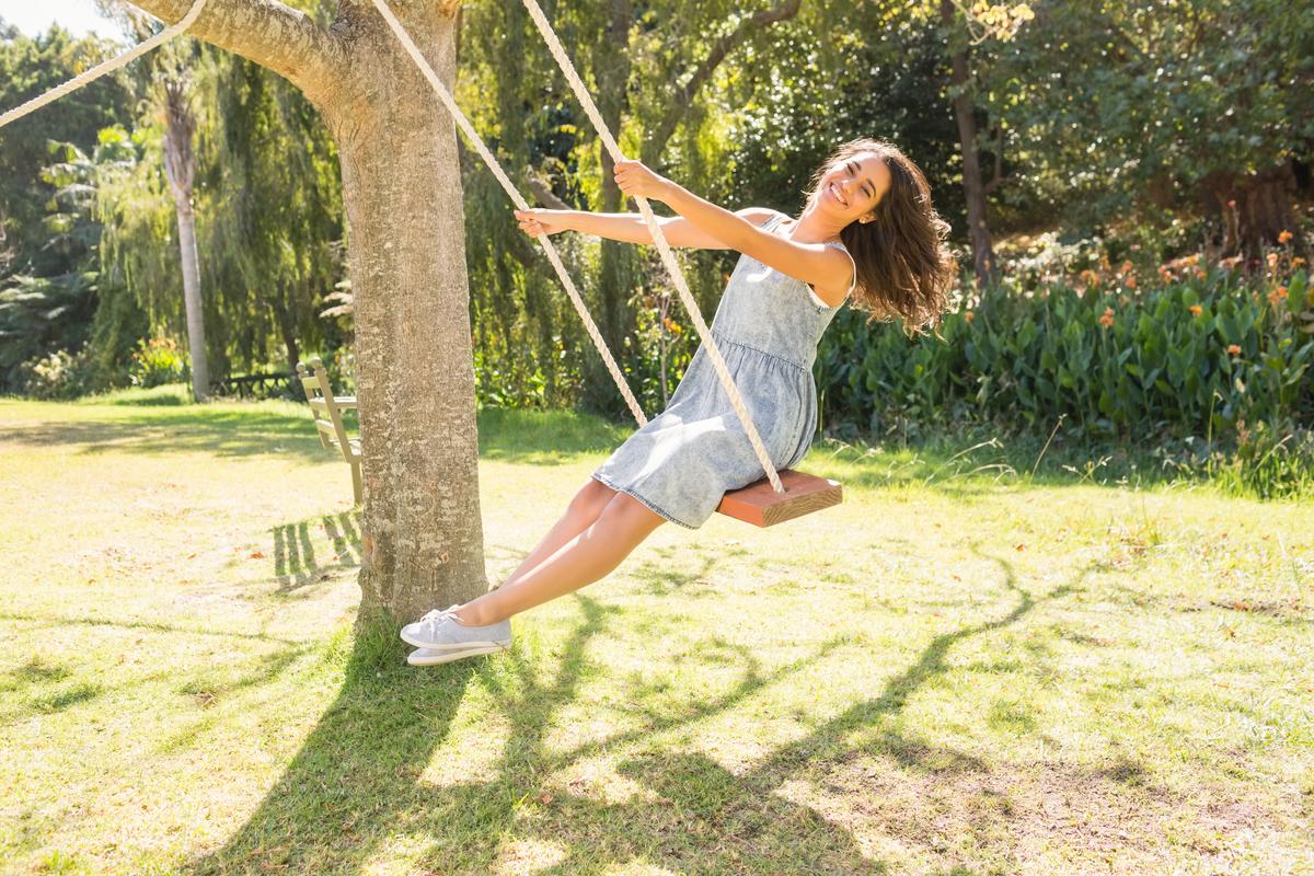 Pretty,Brunette,Swinging,In,Park,On,A,Sunny,Day